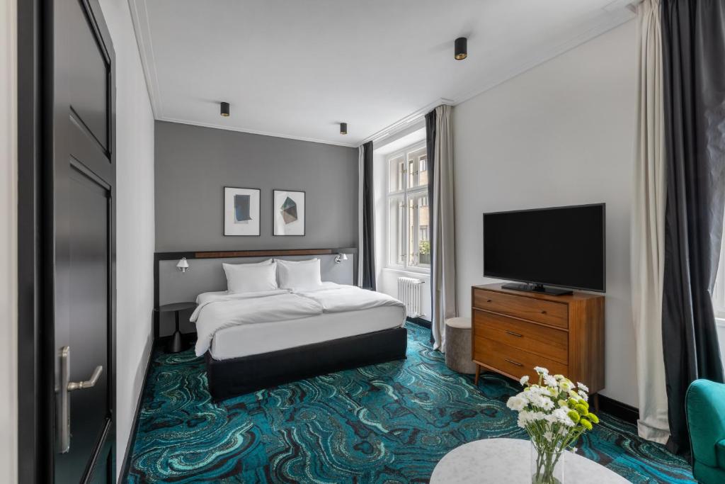 布拉格numa I Republika Rooms & Apartments的配有一张床和一台平面电视的酒店客房