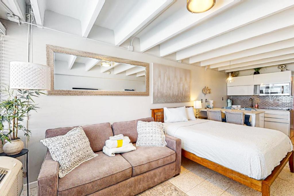 巴拿马城海滩Fontainebleau Terrace 223的一间卧室配有一张床和一张沙发,还设有一间厨房