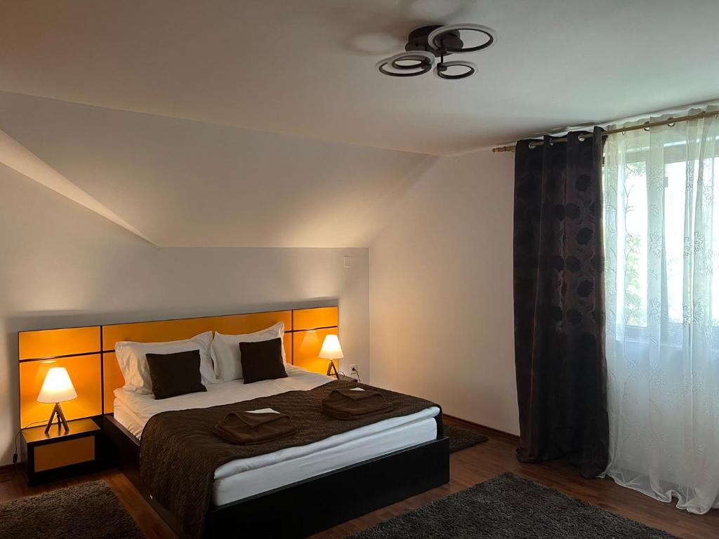 克里尚Vila CAMA的一间卧室配有一张带两盏灯的床和一扇窗户。