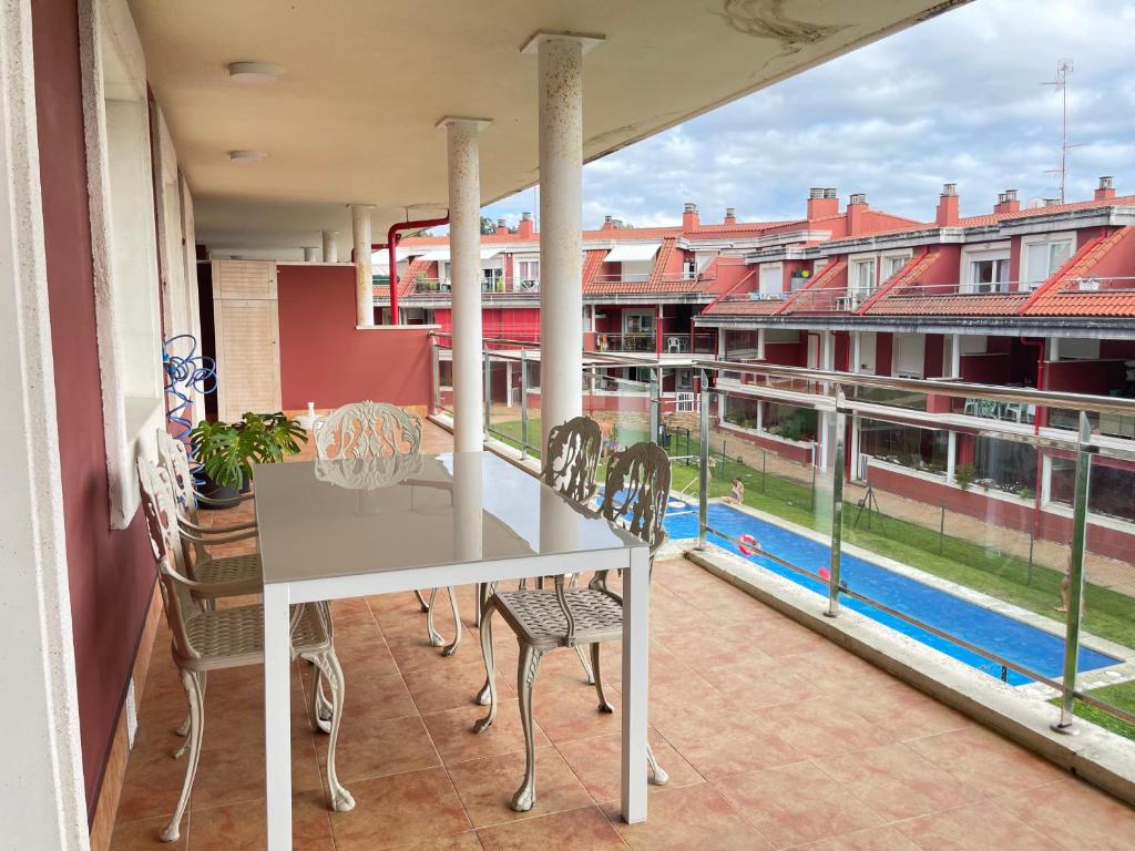 维拉加尔西亚·德·阿劳萨Apartamento Xalda con piscina的阳台配有白色桌椅。