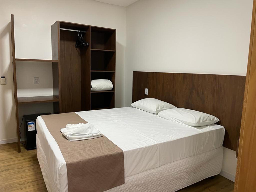 里奥韦尔迪Éden Hotel的一间卧室配有一张带白色床单的大床