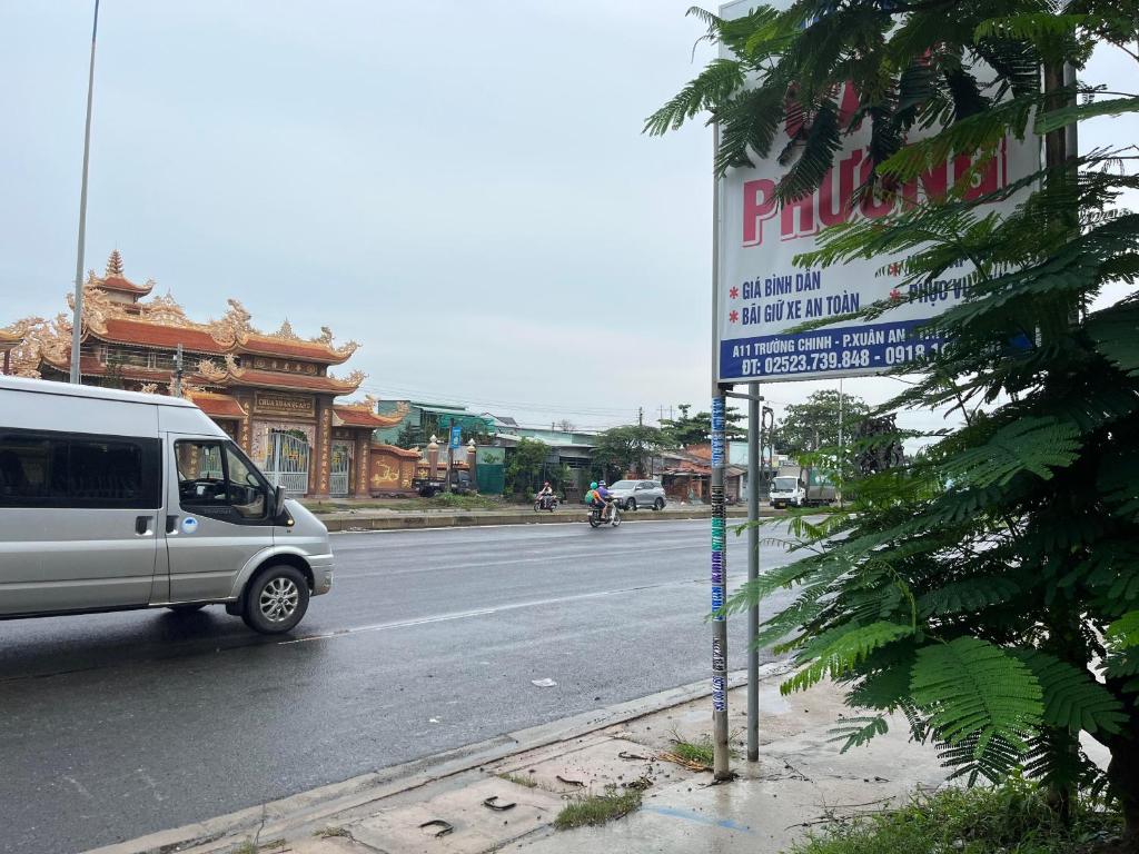 潘切Cát Phượng Motel的一辆白色的面包车,沿着街道行驶,上面有标志