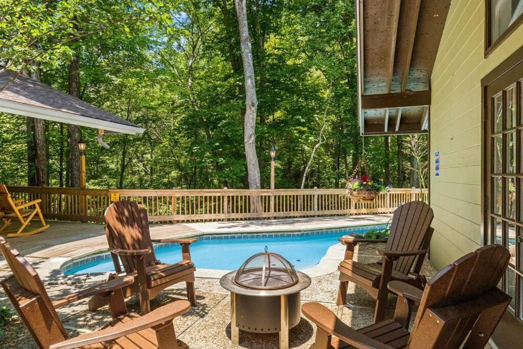 加特林堡Bourbon Hollow Lodge with Hot Tub and Pool plus Game Room only 5 min to downtown的一个有两把椅子的露台和一个游泳池