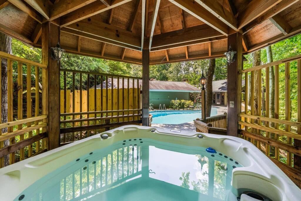 加特林堡Bourbon Hollow Lodge with Hot Tub and Pool plus Game Room only 5 min to downtown的凉亭内的大型露天热水浴池,带游泳池