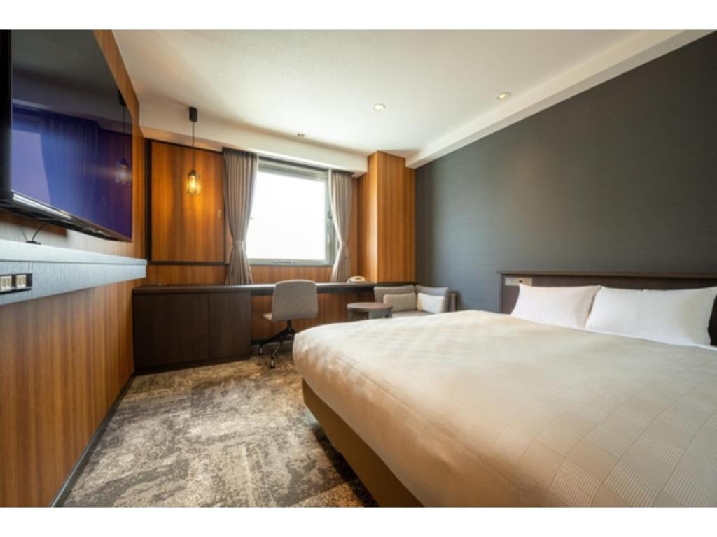 三沢市Misawa City Hotel - Vacation STAY 81764v的酒店客房设有一张大床和一张书桌。