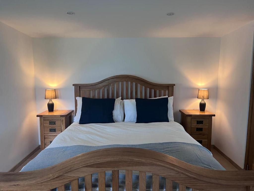 HatherleighLittlewood Cabin的一间卧室配有一张带2个床头柜的大床