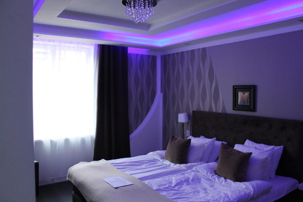 SkänningeSkänninge stadshotell的紫色卧室,配有紫色照明床