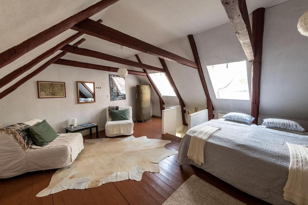 斯塔德Litet gathus mitt i Ystad的阁楼卧室配有两张床和一张沙发