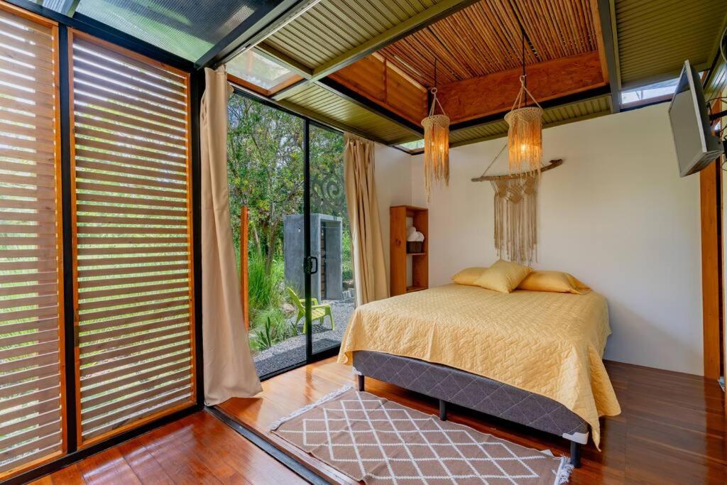 图里亚尔瓦Tiny garden house的一间卧室设有一张床和一个大窗户