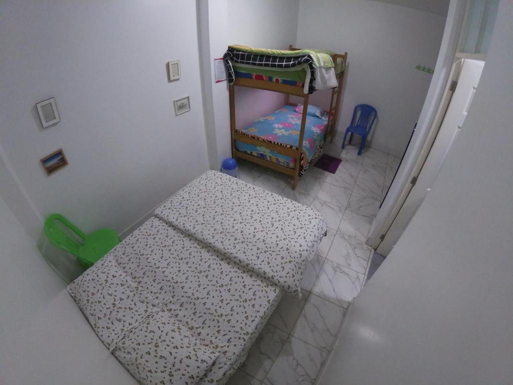 纳斯卡Nanasqa Hostel en Nasca / Nazca的小房间设有桌子和婴儿床
