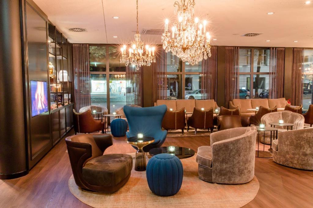柏林文柏林贝勒福汽车旅馆的大堂设有蓝色的椅子和桌子