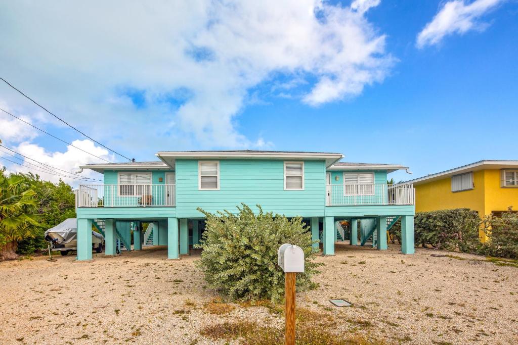 鸭礁岛Lobster Lodge and Manatee Manor的海滩上带阳台的蓝色房屋