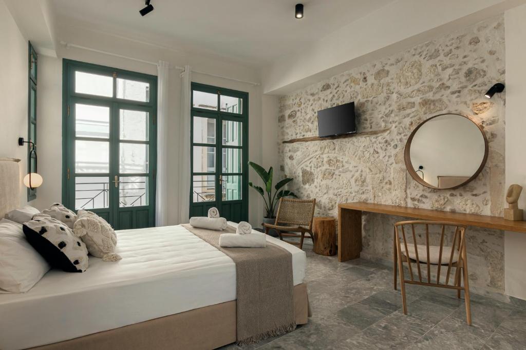 罗希姆诺Soleil boutique house with terrace的一间卧室配有一张大床和镜子