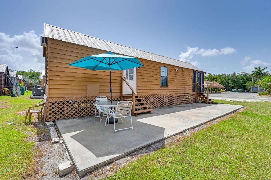 大沼泽地市Everglades Rental Trailer Cabin with Boat Slip!的小屋配有桌子和雨伞