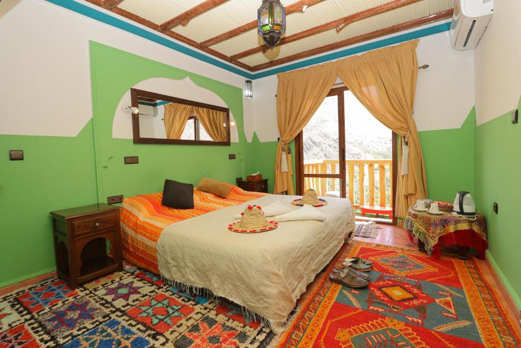 伊姆利尔Atlas Prestige的一间设有床铺的卧室,位于一个拥有绿色墙壁的房间