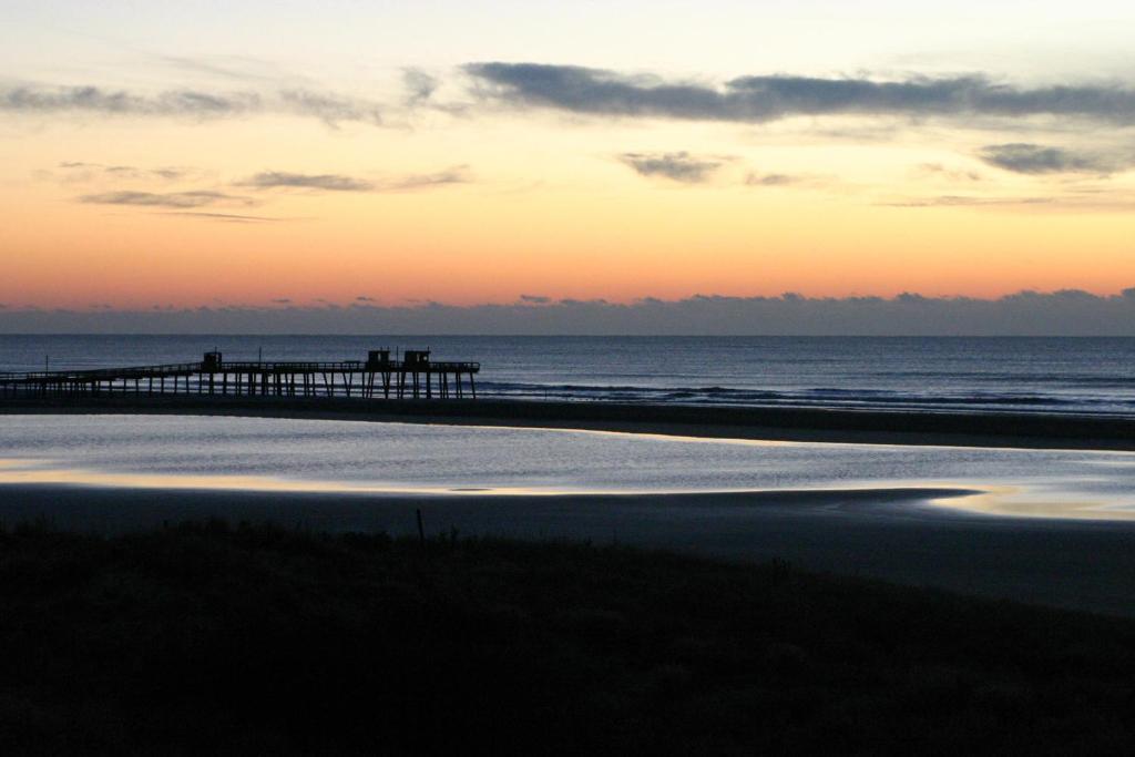 威尔伍德克拉斯特拿骚酒店的日落时分有码头和海洋的海滩