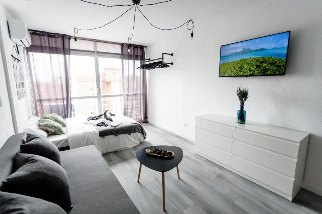 贝尼多姆Modern studio with see and city view的客厅配有沙发和墙上的电视