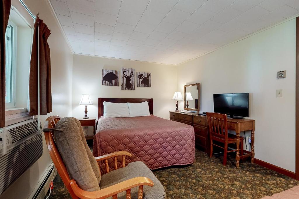 林肯Riverbank Connecting Motel Rooms 4 & 6的酒店客房配有一张床、一张书桌和一台电视。