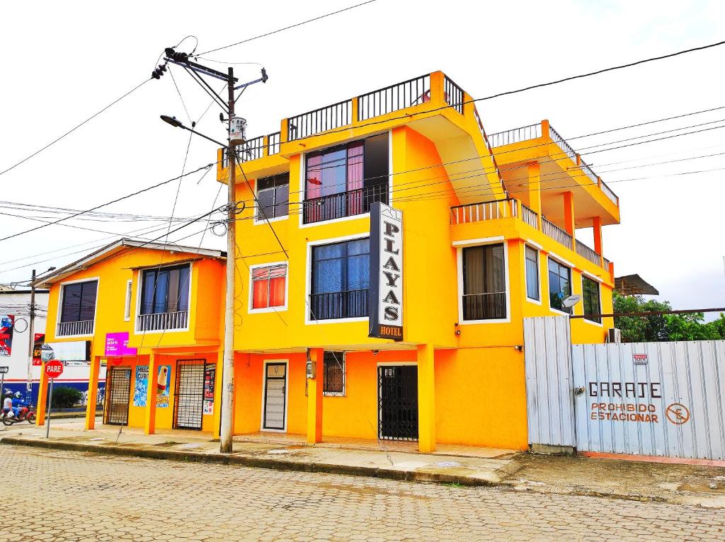 佩德纳莱斯HOTEL PLAYAS PERDERNALES ECUADOR的街道边的黄色建筑