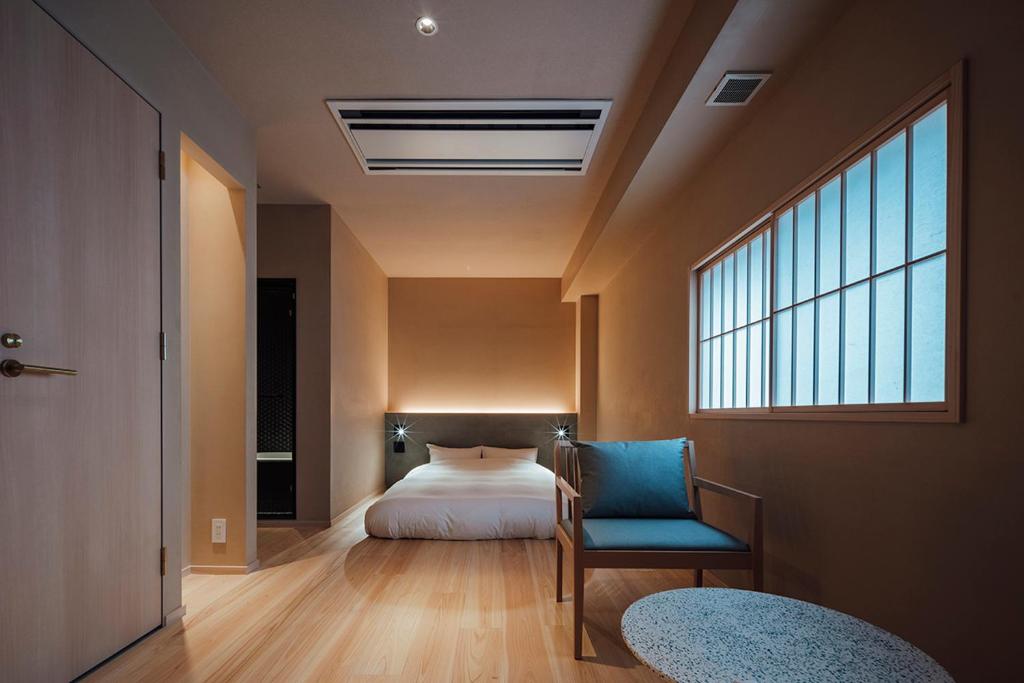 吴市無垢　入船の宿的卧室配有床、椅子和窗户。