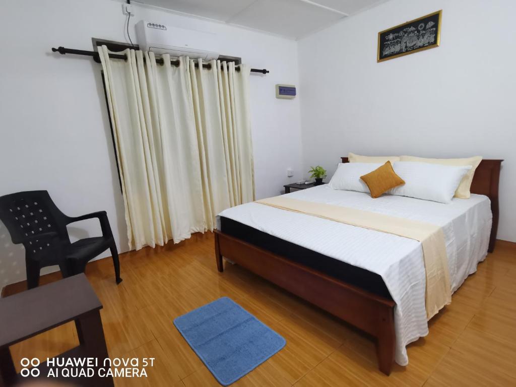 尼甘布Bee Cottage Negombo的一间卧室配有一张床和一把椅子