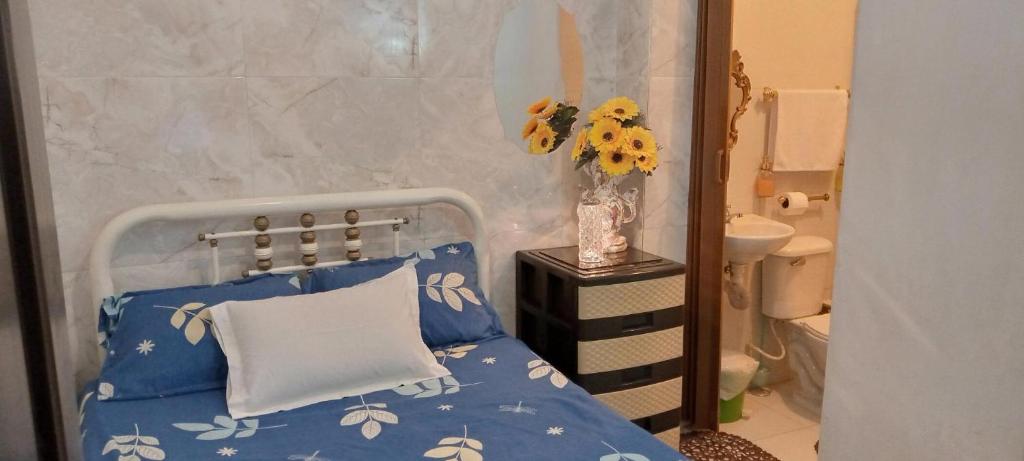 瓜亚基尔Acuarela del Rio H#3 Cerca Aeropuerto y Terminal Habitación privada con baño的一间卧室,配有一张床和花瓶