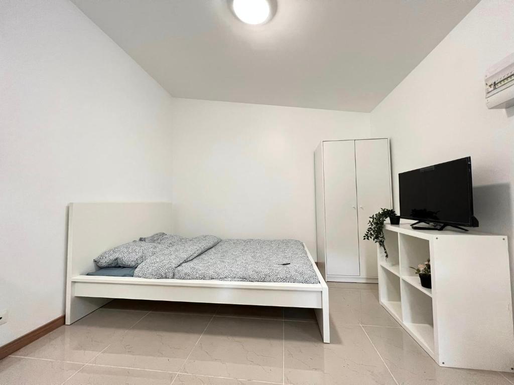 GagnyGagny super studio très calme的白色卧室配有床和平面电视