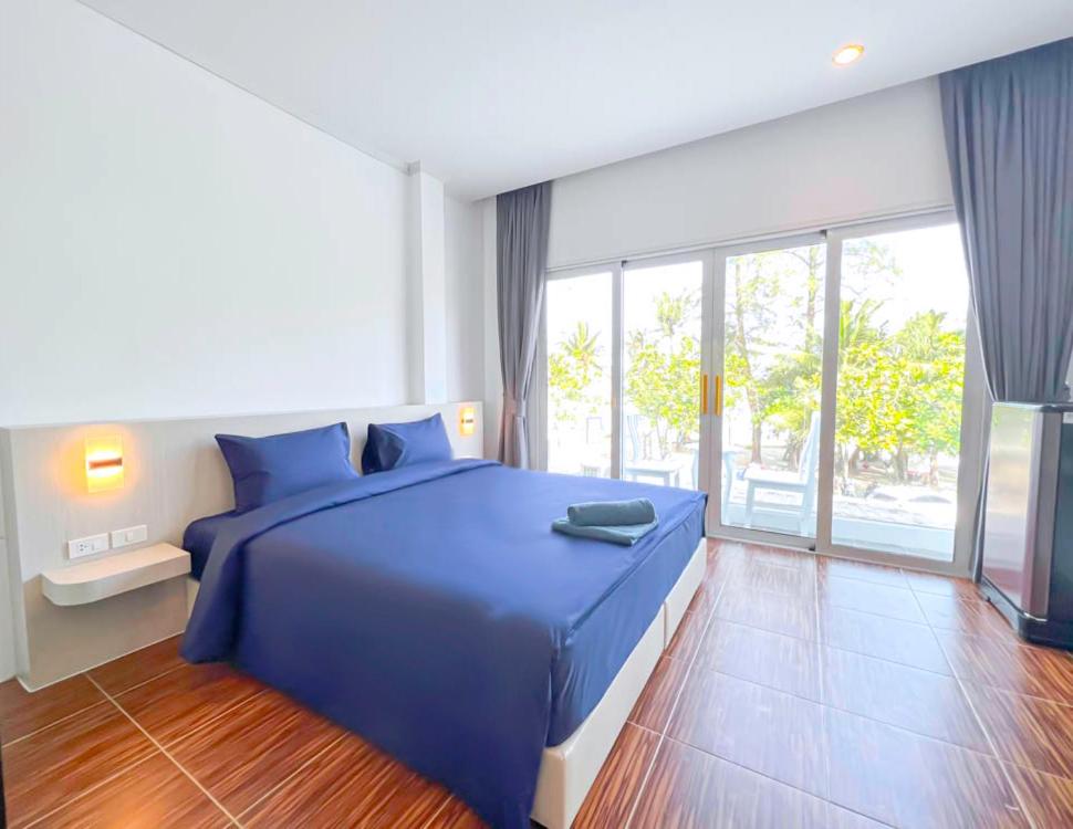 芭东海滩88 House Patong的一间卧室设有蓝色的床和大窗户