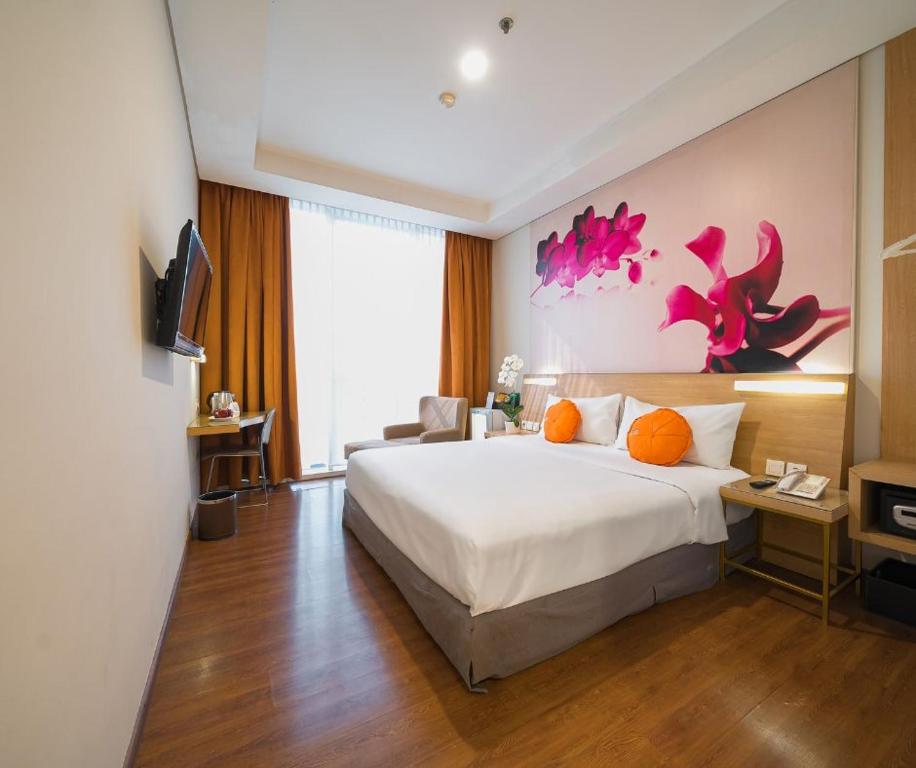 雅加达Grand G7 Hotel Pasar baru的酒店客房设有一张大床和一台电视机。