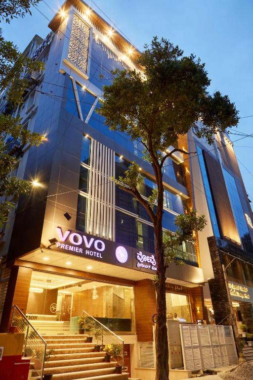 班加罗尔VOVO PREMIER HOTEL的前面有棵树的建筑