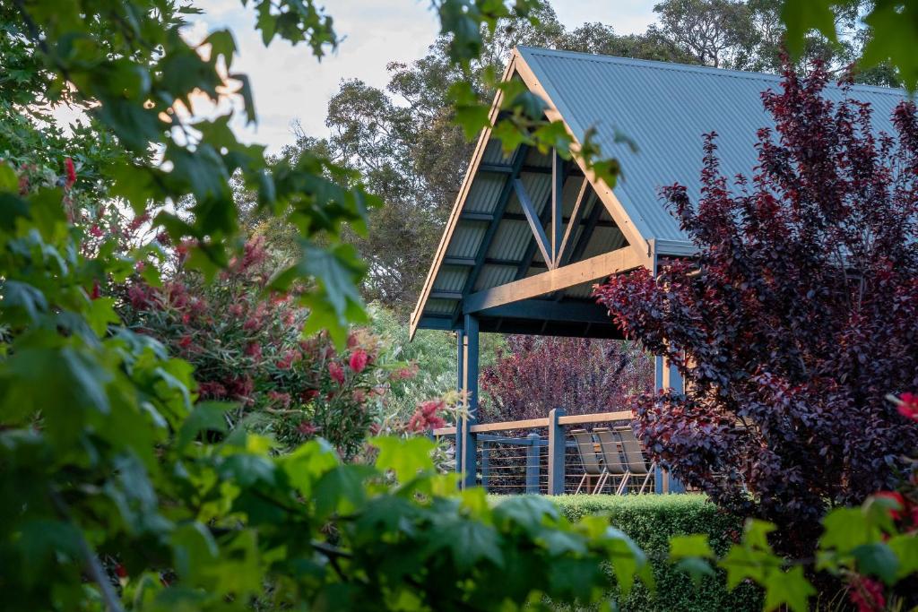 亚林加普Kangaroo Lodge - Yallingup的树后有蓝色屋顶的房子