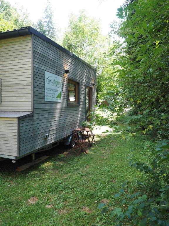 瓦尔茨胡特田根Tiny House am idyllischen Schlüchttal Naturcampingplatz的停在草地上的一辆灰色火车车