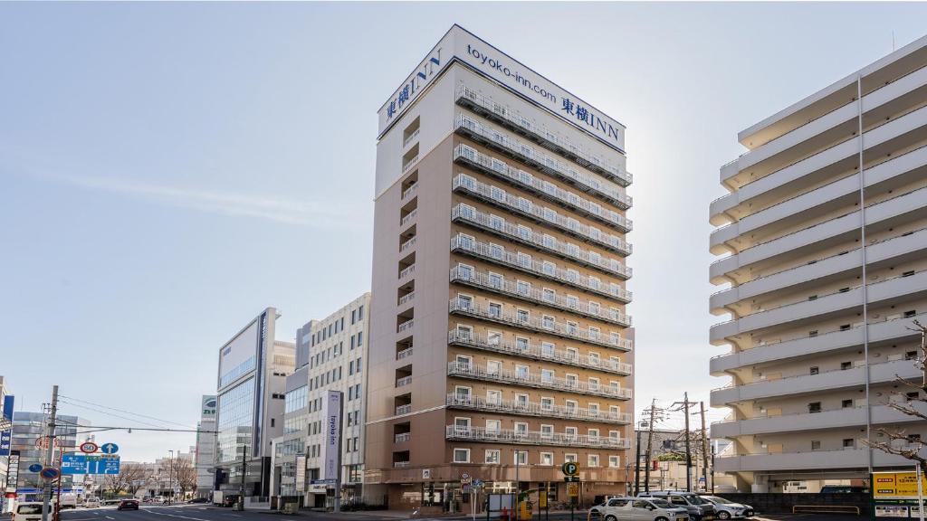 静冈Toyoko Inn Shizuoka eki Kita guchi的一条城市街道上高大的白色建筑