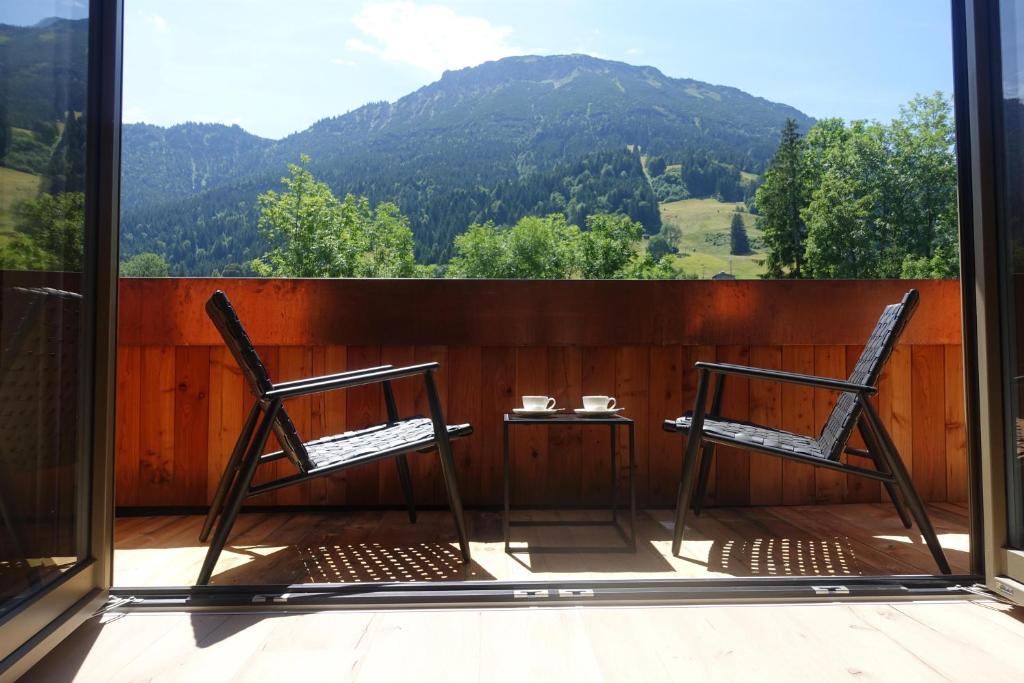 普夫龙滕Alpinchalet的山景阳台上配有两把椅子和一张桌子