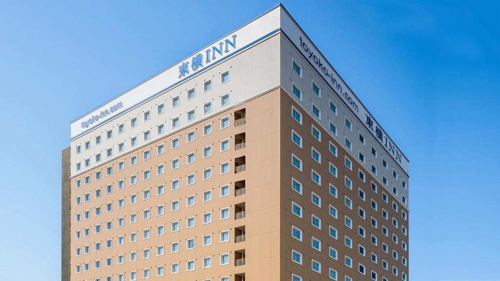 印西Toyoko Inn Imba Nihon-idai Ekimae的一座高大的建筑,上面有亚马逊标志