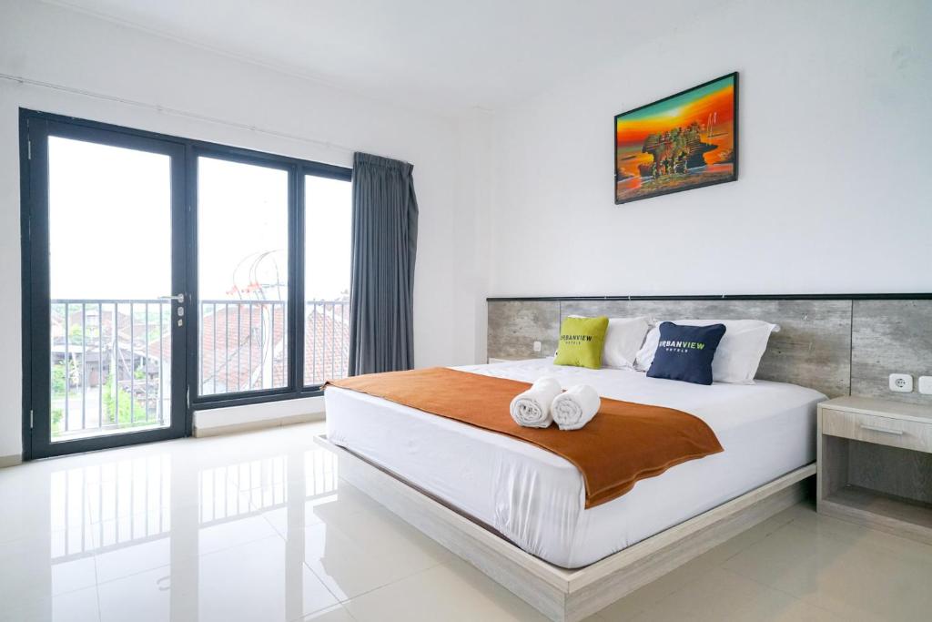 乌干沙Urbanview Pecatu Residence Bali by RedDoorz的一间卧室设有一张大床和一个大窗户