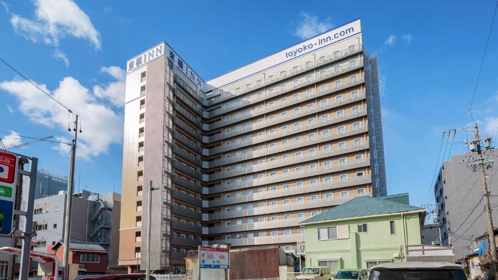 名古屋Toyoko Inn Nagoya Kanayama的一座高大的建筑,上面有标志