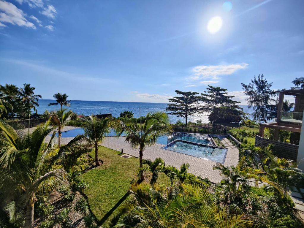 潘托皮芒Ocean Point Beach Front Apartment的享有度假胜地的空中景致,设有游泳池和海洋