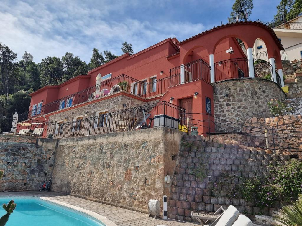 泰晤勒·苏尔·梅尔VILLAS and SUITES LA CORAILLERE RESORT的石墙顶部的房屋,设有游泳池