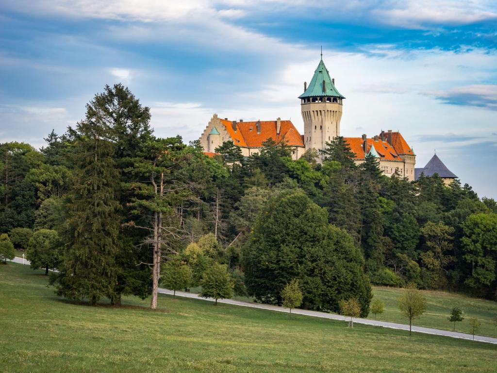 斯莫列尼茨Smolenický zámok的一座树冠茂密的山顶上的城堡