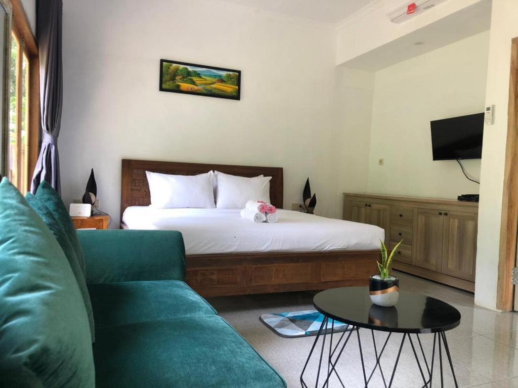 PawenangBale Kebon Rangsot的一间卧室配有一张床、一张沙发和一张桌子
