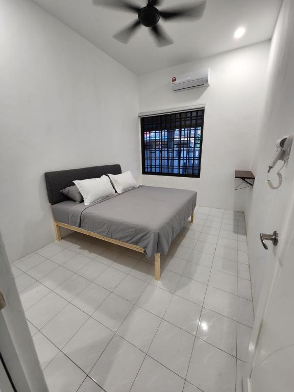 丰盛港4 bedroom homestay @ Mersing的一间卧室配有一张床和吊扇