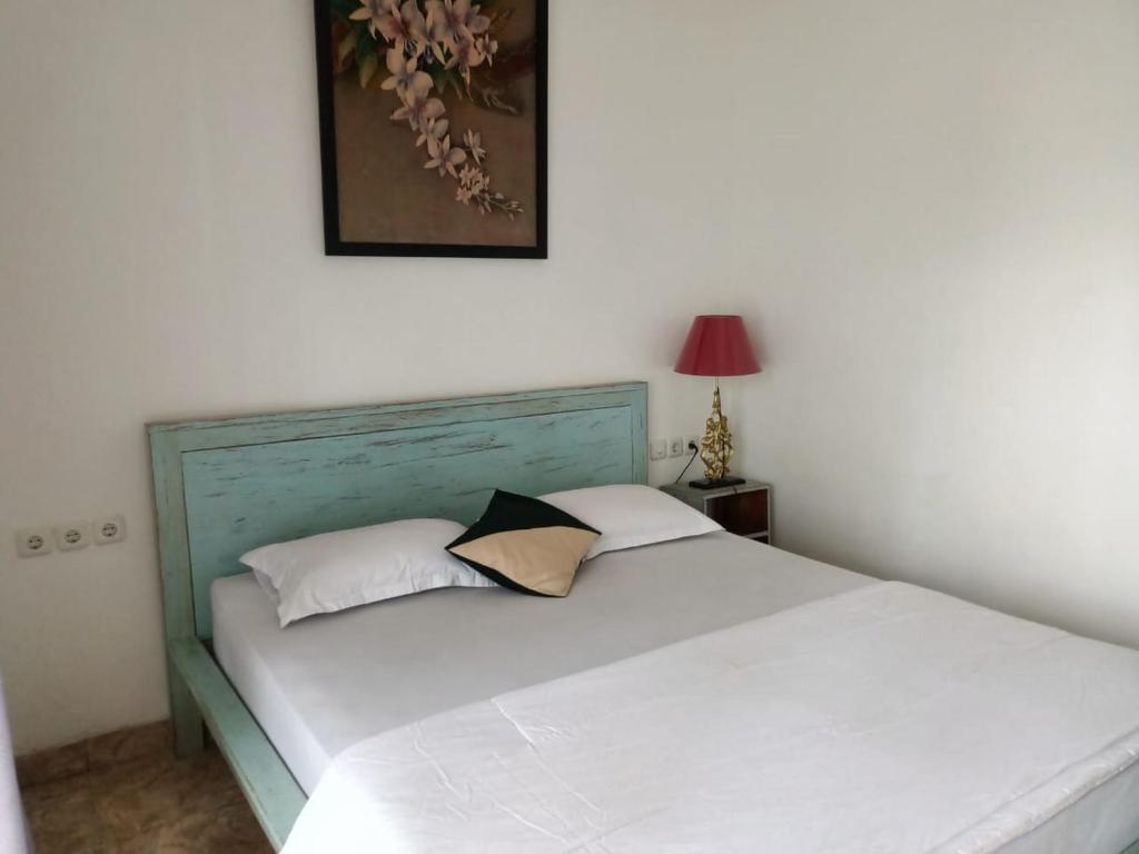 日惹RedDoorz at Griya Cemara Homestay Yogyakarta的卧室内的一张带两个枕头的床