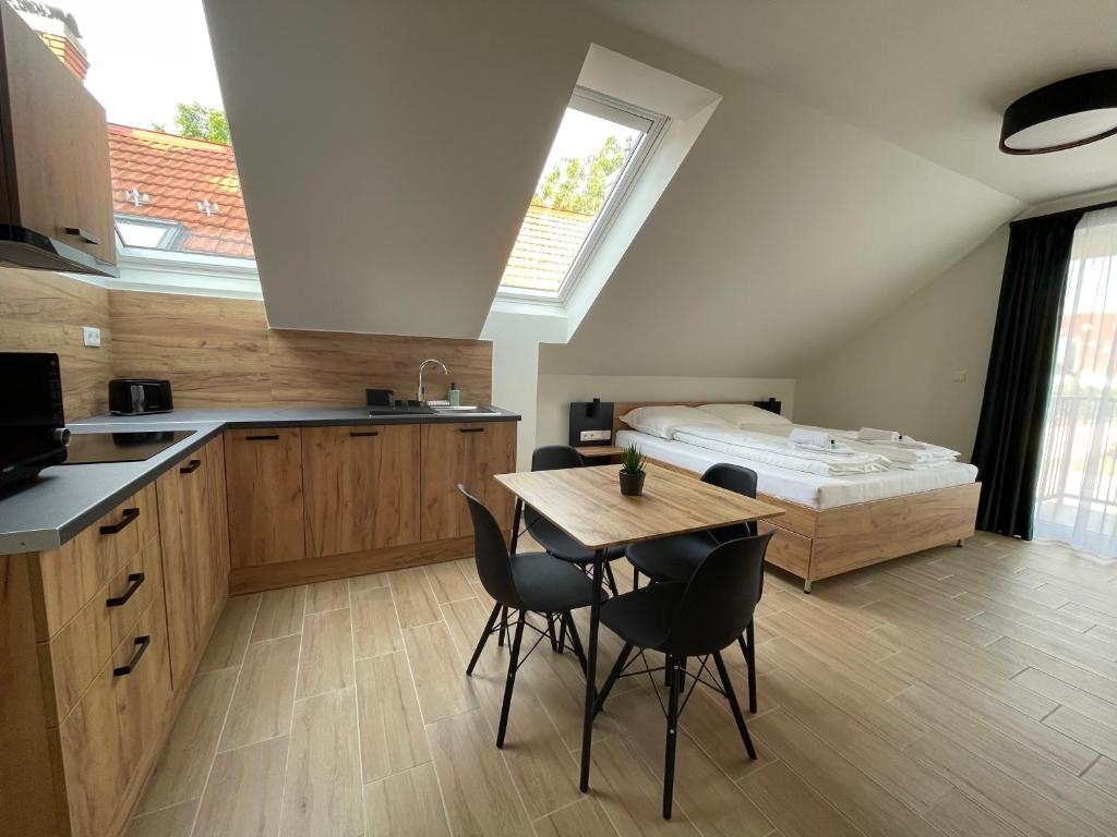 塞格德Rezidex Apartmanház的厨房配有桌椅和1张床