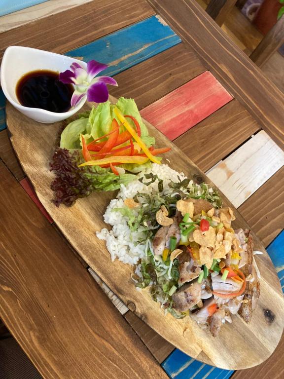 北谷町Surfer's Cafe& Hostel的餐桌上放着一盘饭和蔬菜的食物
