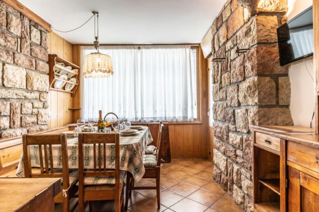 科雷多Casa del Pinter, Coredo Ospitar的一间设有桌子和石墙的用餐室
