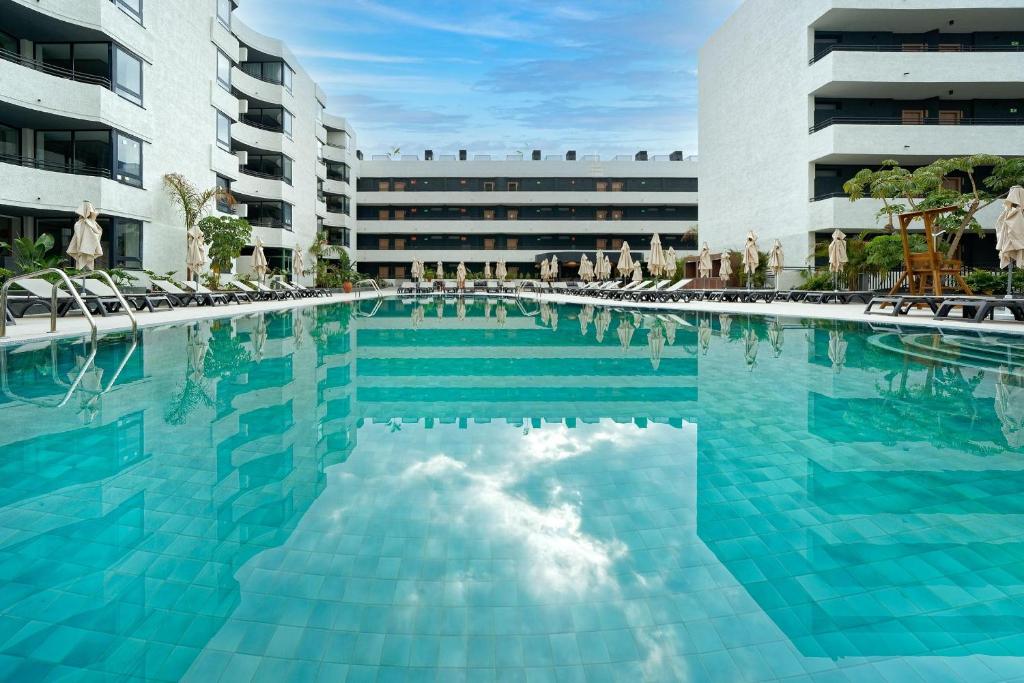 阿德耶Labranda Suites Costa Adeje的一座带椅子的大型游泳池和一座建筑