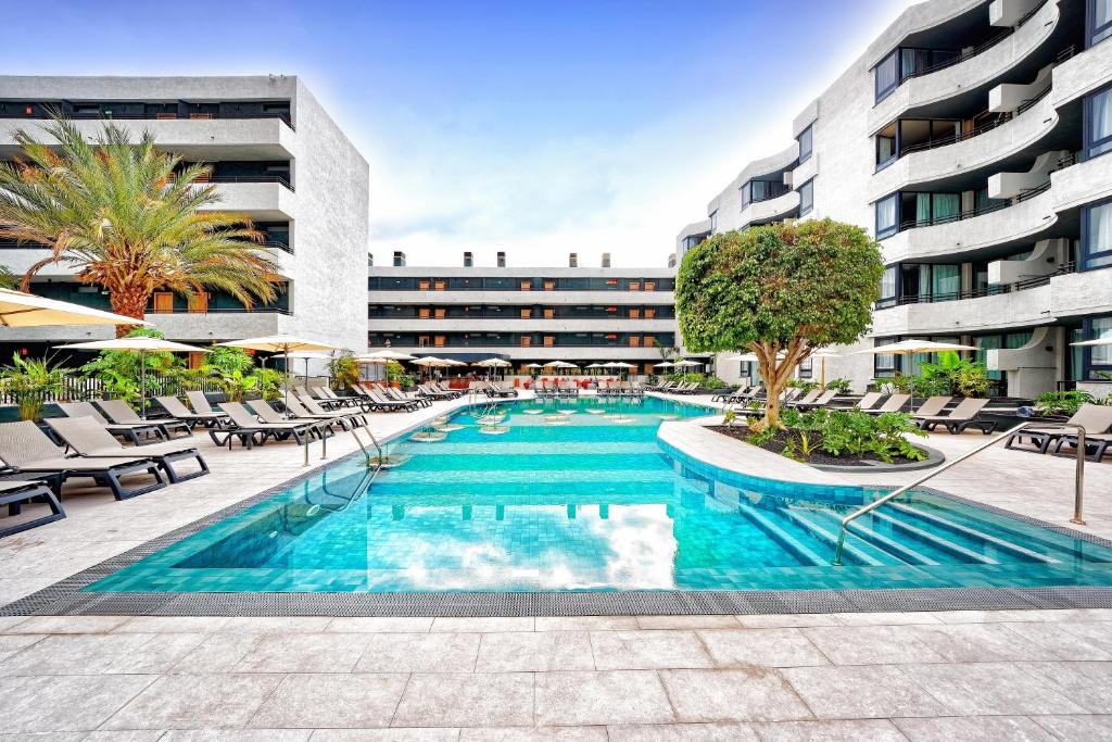 阿德耶Labranda Suites Costa Adeje的大楼前的游泳池