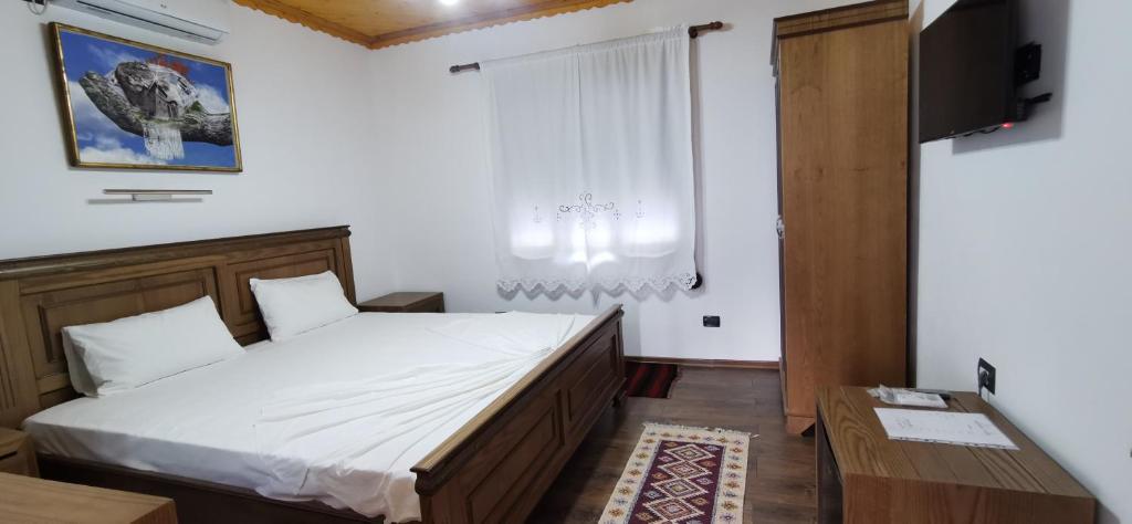 吉诺卡斯特Hazmurat Hotel的一间卧室配有一张床、一台电视和一个窗口
