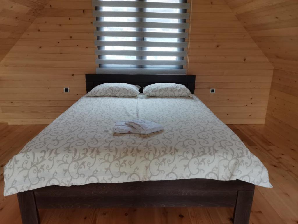Sekulić Brvnare Libero TARA的卧室配有一张带白色棉被的床和窗户。